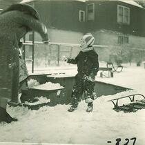 Small boy and woman playing in the snow, The University of Iowa, January 1938