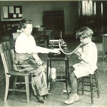 Assisting a child recording voice with Edison dictaphone, The University of Iowa, circa 1920