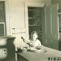 Boy using hand food grinder, The University of Iowa, January 12, 1938
