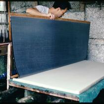 Kubo-san lowering the su down and across pile of previously couched sheets, Ogawa-machi, Saitama Prefecture, Japan, circa 1976