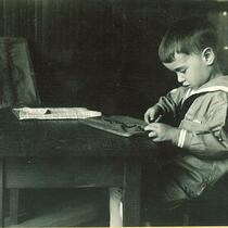 Boy practicing buttoning, The University of Iowa, circa 1920