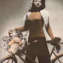 Arlene Roberts posing with a bike and a basket full of vegetables, 1946